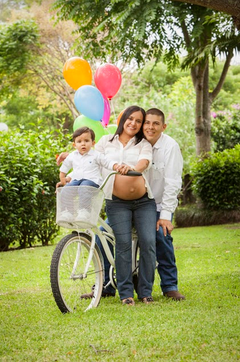 family picture. mom and dad with baby in a bicycle basket