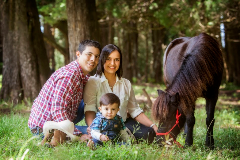 family portrait, mom and dad with baby and a pony