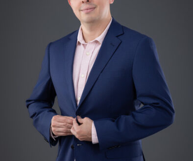 Hombre con blazer azul marino y camisa rosada en sesión profesional de marca personal